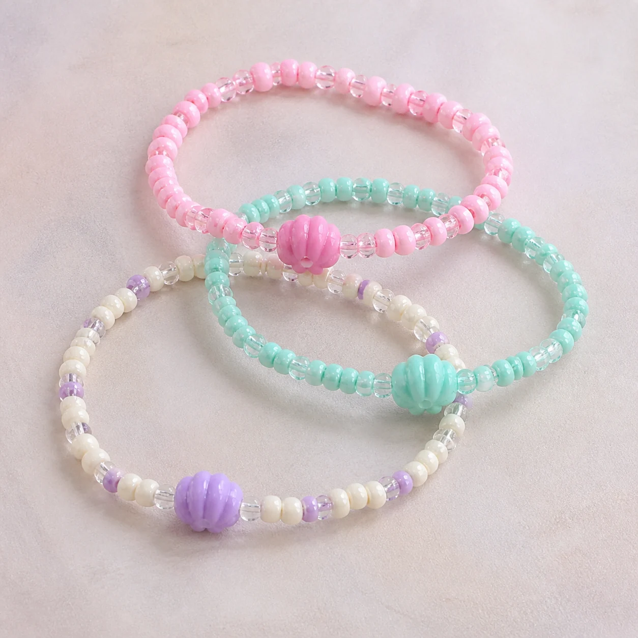 Conceptbeeld van drie Soft Pastel Stack-armbandjes voor één pols.